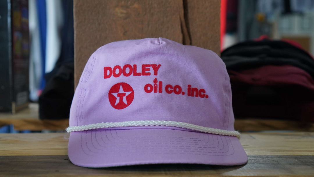  Vintage Dooley Oil Co. purple snapback rope hat from the 90s, featuring the company logo, available from West Block Vintage—perfect for enthusiasts of vintage rope and snapback hats.